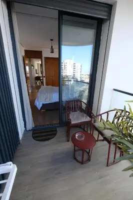 a balcony with a room with a bed and a table at Appartement chic et cosy - Casablanca Finance City in Casablanca