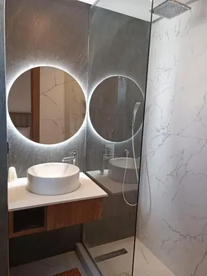 a bathroom with two round mirrors and a sink at Signature Leving 119 in Casablanca