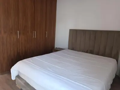 a bedroom with a white bed with wooden cabinets at Signature Leving 119 in Casablanca
