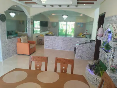 a dining room with a table and four chairs at RiadNA bouznika in Bouznika