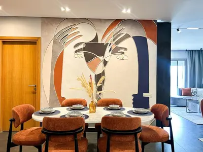 a dining room with a table with chairs and a painting at Luxury apartment Marina in Casablanca