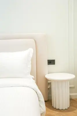 a white bed with a white table in a room at Cosy cocon Racine in Casablanca