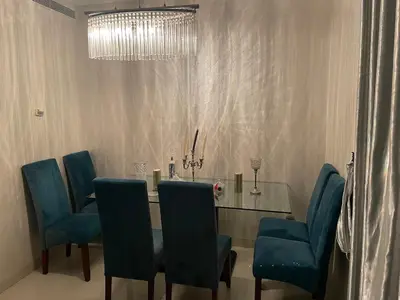 a dining room with a glass table and blue chairs at Beachside Charming Apartment in Tamaris