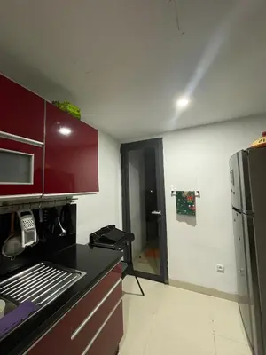 a kitchen with red cabinets and a black counter top at Beachside Charming Apartment in Tamaris