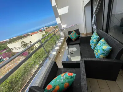a balcony with a couch and a view of the ocean at Beachside Charming Apartment in Tamaris