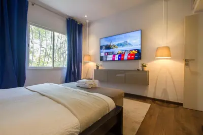 a bedroom with a bed and a tv on the wall at Charming 3 Bedroom Apt in Agdal in Rabat