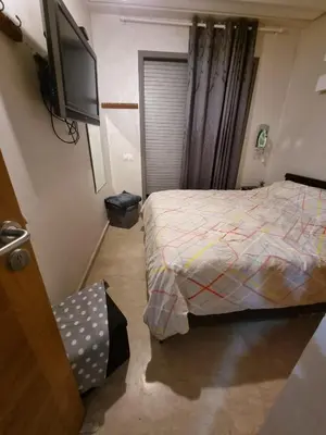 a small bedroom with a bed and a flat screen tv at Heart of Casablanca - Tramway in Casablanca