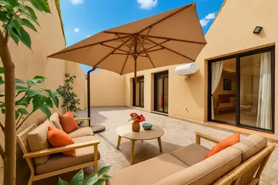 a patio with two couches and an umbrella at Cosy Patio sunny 2BR - new building - near oasis train station in Casablanca