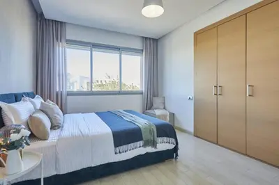 a bedroom with a bed and a large window at Family-Friendly 3BR with Garden and Outdoor Space in Bouskoura