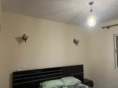 a bedroom with a bed and two lights on the wall at Appartement Magnifique au coeur de la Corniche de Rabat in Rabat