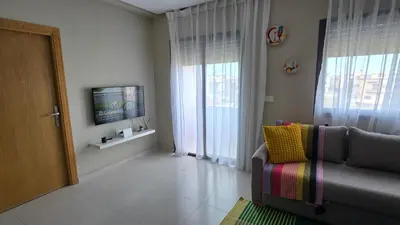 a living room with a couch and a television at Nice Studio Casablanca Mohammed V Airport in Derroua