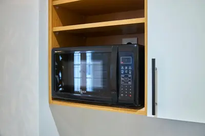 a microwave oven in a cabinet in a kitchen at Suite DeLuxe au coeur de la ville in Casablanca