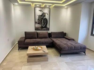 a living room with a couch and a motorcycle on the wall at downtown luxurious flat quartier Gauthier in Casablanca