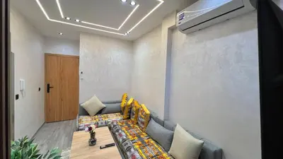 a living room with a couch and a child sitting on it at Studio chic et confortable au coeur de rabat agdal in Rabat