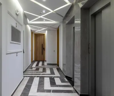 a corridor of an office building with a tile floor at Elégant et moderne appartement à 10 min du centre de Casablanca in Casablanca