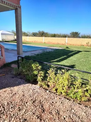 a fence in front of a yard with a field at Ferme a Ain Tizgha Benslimane in O Ben Slimane