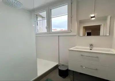a white bathroom with a sink and a window at Appartement cosyy in Casablanca