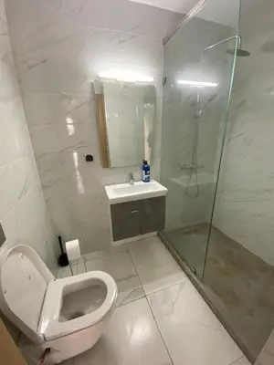 a bathroom with a toilet and a shower and a sink at Résidence Sheren in Casablanca