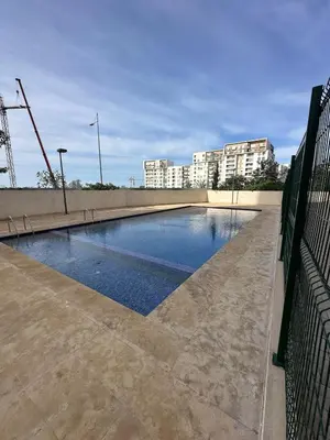 an empty swimming pool with buildings in the background at Unique apartment in Prestigia Hay Riad Rabat in Rabat