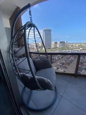 a chair on a balcony with a view of a city at Central Luxury Apartment with Fast Fiber WiFi, Panoramic Balcony & Free Parking in Casablanca CFC Casa Finnance City in Casablanca