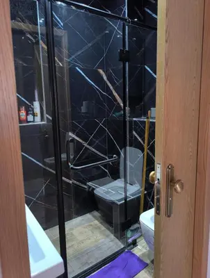 a bathroom with a glass shower with a toilet at apartment a casablanca in Dar Ben Abdallah Ben Dehbi