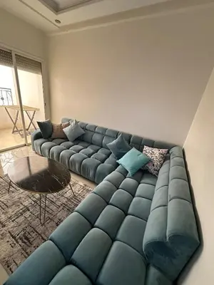 a living room with a blue couch and a table at Chic, quiet and convenient apartment in Casablanca