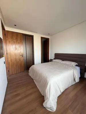 a bedroom with a large white bed and wooden floors at Appartement Casa finance city Studio Haut standing in Casablanca
