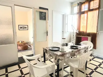 a dining room with a table and white chairs at Comfortable Room 2 at Homestay Casablanca in Maarif