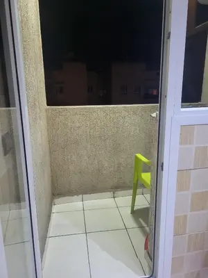 a green chair sitting on a balcony next to a door at Appartement à Casablanca in Casablanca