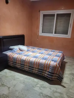 a bedroom with a bed with a blanket and a window at Appartement à Casablanca in Casablanca