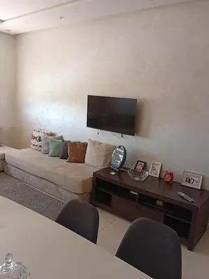 a living room with a couch and a flat screen tv at Appartement Jad & Rim in Bouznika