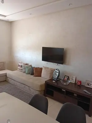 a living room with a couch and a flat screen tv at Appartement Jad & Rim in Bouznika