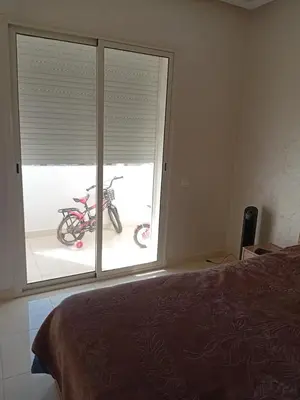 a bedroom with a window with a bike parked outside at Appartement Jad & Rim in Bouznika
