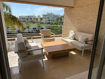 a balcony with two chairs and a coffee table at Bouznika Bay Villa Prestigious Oasis in Sidi el Haj Bou Derbala