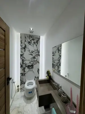 a bathroom with a toilet and a large mirror at Appartement VictoriaBouskoura in Casablanca