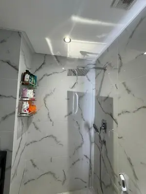 a bathroom with a white marble wall at Appartement VictoriaBouskoura in Casablanca