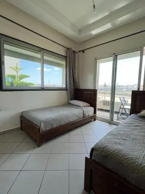 a bedroom with two beds and a large window at Mansoria in Mansouria