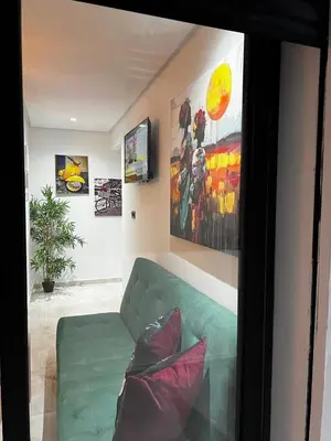 a living room with a green couch and paintings at Skyline Urban - by Nero in Casablanca