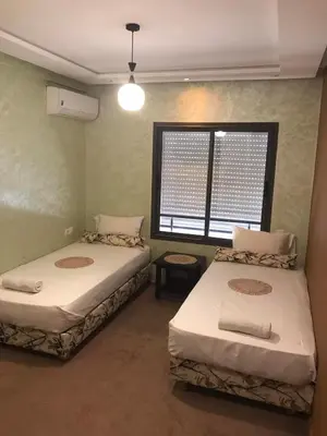two beds in a room with a window at Comfort Stay by Mohammed V Airport in Nouaseur