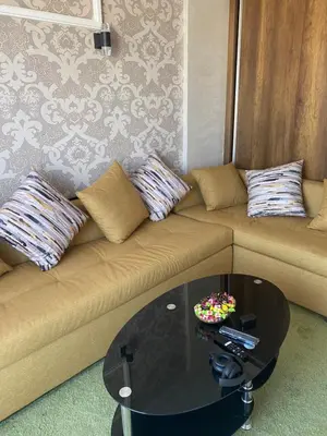 a living room with a couch with pillows and a table at Jnane in Sidi Rahal