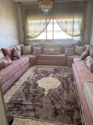 a living room with a large couch and a window at Jnane in Sidi Rahal