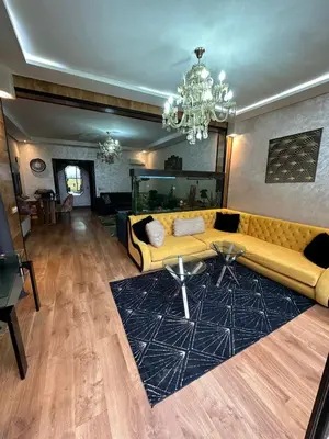 a living room with a yellow couch and a rug at Appartement à Dar bouaaza in Tamaris