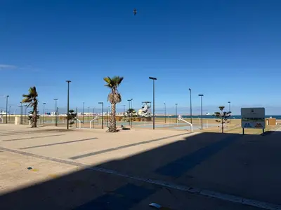 a empty street with palm trees and the beach at Appartement de lux avec piscine in Mohammedia