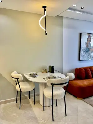 a table and chairs in a living room with a couch at Bat infinity living in Casablanca