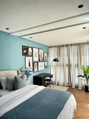 a bedroom with a blue wall with a bed and a desk at Luxury 1-Bedroom Apartment in Maarif in Casablanca