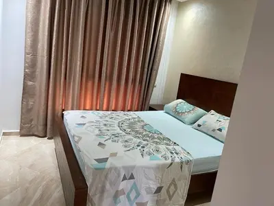 a bedroom with a bed and a window with curtains at Ramoflores , sidi rahal in Sidi Rahal