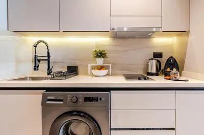 a kitchen with a sink and a washing machine at Corniche Guest idéal pour un séjour Inoubliable in Casablanca
