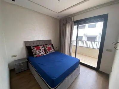 a bedroom with a blue bed with a balcony at Appt 1 ch meublé CFC TO CLOSE in Casablanca