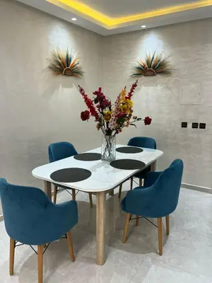 a dining room table with blue chairs and a vase of flowers at Dar al bahr in Rabat