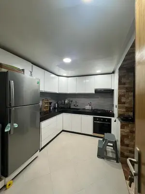 a kitchen with white cabinets and a stainless steel refrigerator at Dar al bahr in Rabat
